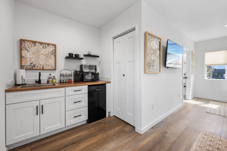 This modern, well equipped kitchenette with a small fridge, microwave, toaster oven/air fryer combo, and Keurig coffee maker -perfect for effortless meals and morning coffee with a small nook seating for two.