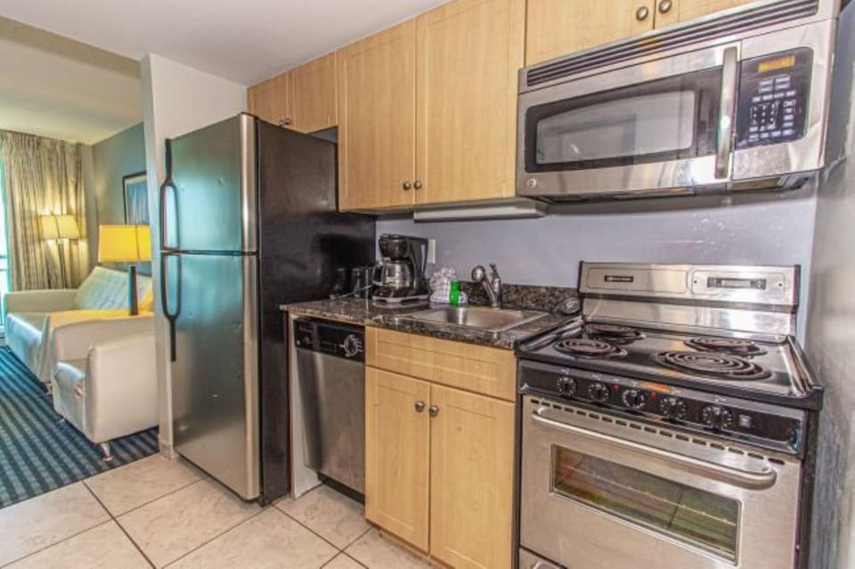 Fully stocked kitchen with coffee maker, sink, and dishwasher.