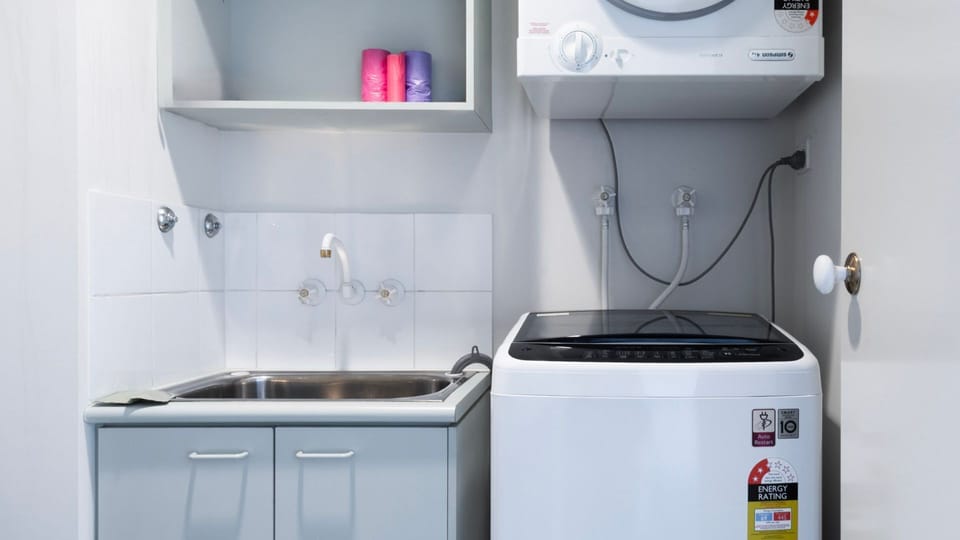 A highly functional laundry utility room cleverly equipped with a separate wash trough and space-saving wall-mounted dryer.