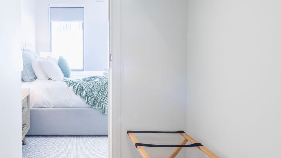 Walk into a bright, inviting bedroom space seamlessly tucked away down a private minimalist hallway.