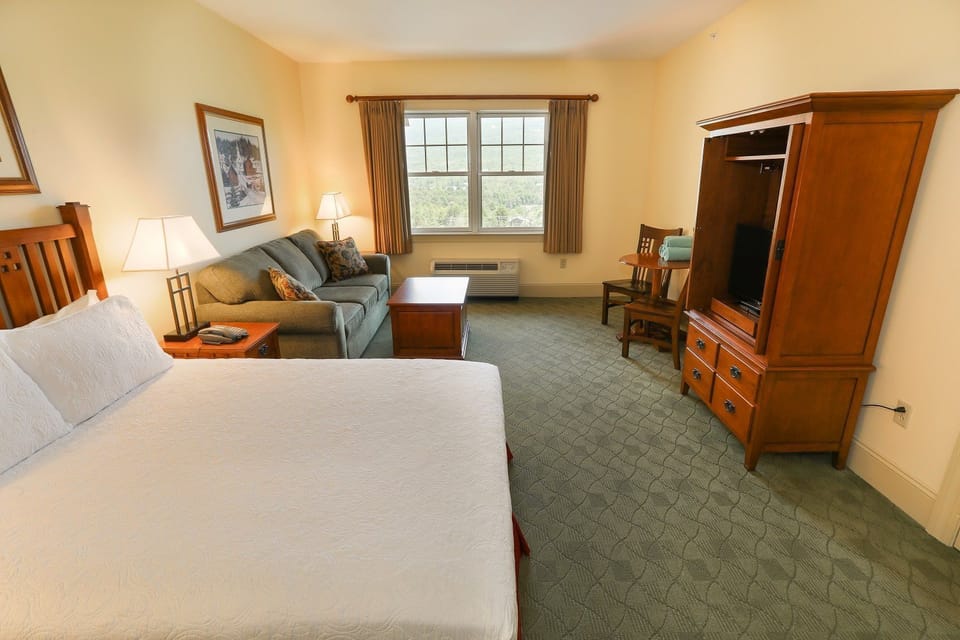 Room with plush bed and comfortable seating area, perfect for relaxing.