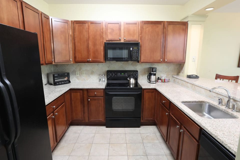 Warm and inviting kitchen with rich wood cabinetry and sleek countertops, perfect for preparing meals with ease.