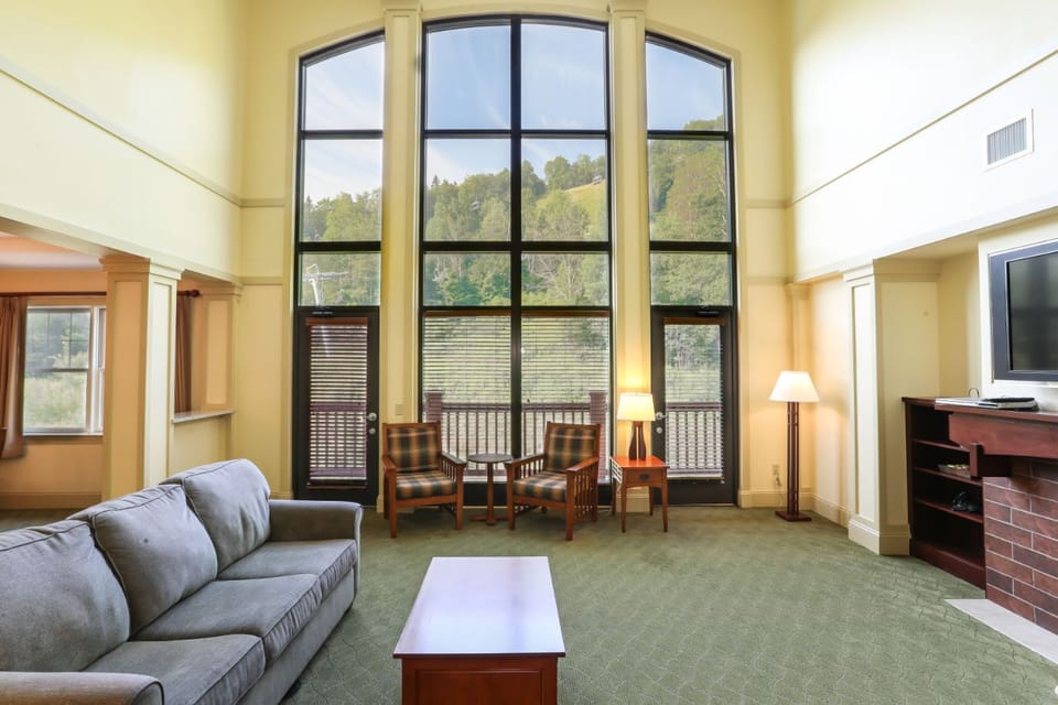 Sunlit living space with soaring windows and stunning views, perfect for relaxation and unwinding.