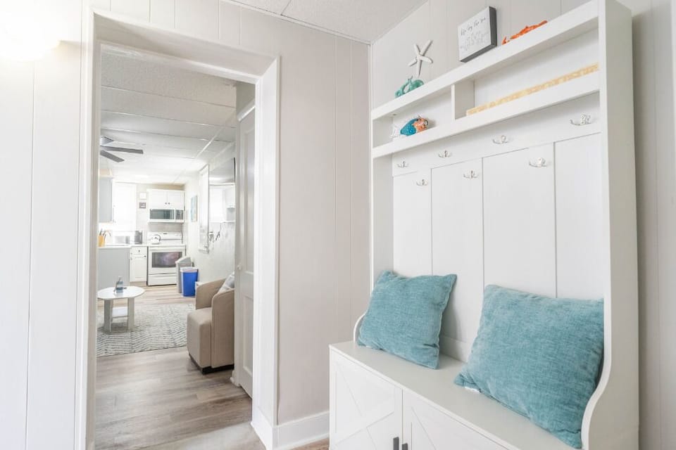 The entryway flows effortlessly into a bright open-plan kitchen and lounge, with coastal accents and comfy seating welcoming you home. A perfect blend of charm and function.