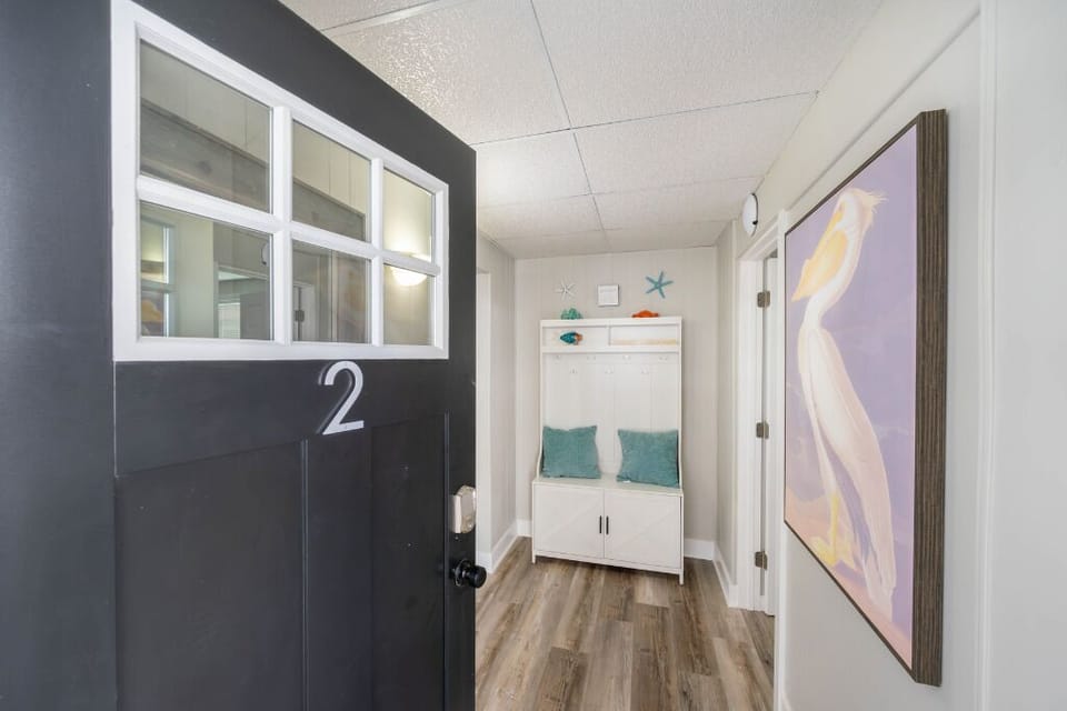 Step into a bright, inviting space with coastal touches, stylish decor, and a cozy bench area perfect for kicking off your shoes and settling in.