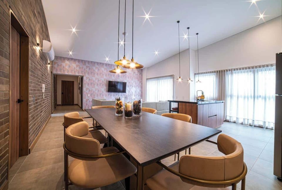 Spacious open layout with dining table, kitchen with bar and living area with SmartTV.