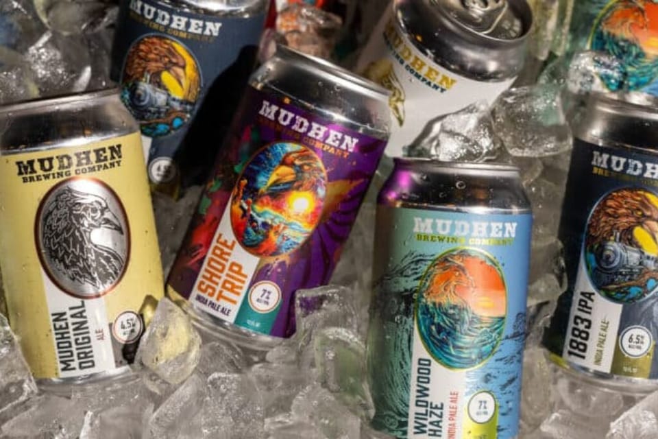 Chilled craft beer selection displayed on ice, featuring colorful cans from a local brewery. Perfect for relaxing after a beach day or enjoying a casual evening with friends.