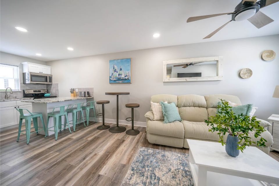 Relax in this airy open-plan space featuring soft coastal tones, a fully equipped kitchen with bar seating, and a comfy lounge - perfect for unwinding after a day of sun and sea.
