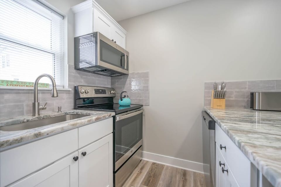 Modern and functional kitchen with full-size appliances, sleek counters, and open shelving. Perfect for cooking, dining, or just enjoying a relaxed morning coffee in a bright and well-designed space.