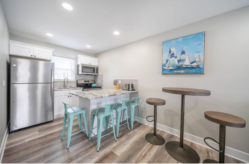 Coastal charm meets convenience in this modern kitchen, featuring stainless steel appliances, bar seating, and nautical accents—perfect for morning coffee, casual bites, or unwinding after the beach.
