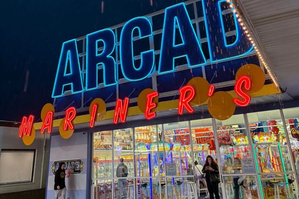 Bright arcade on the boardwalk with neon lights and classic games. A fun stop for all ages, perfect for evening развлечения, prizes, and nostalgic seaside entertainment.