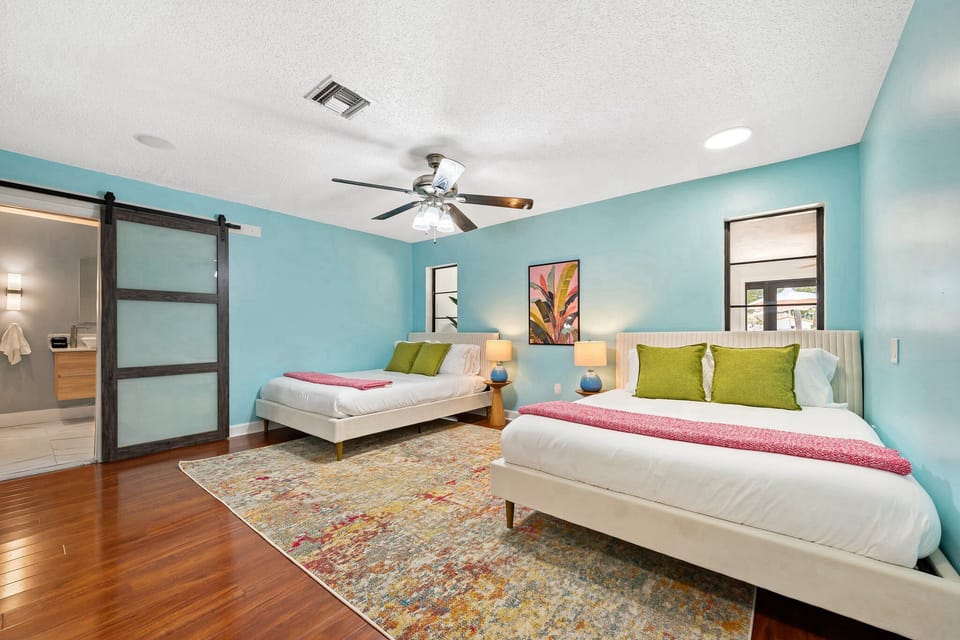 Bedroom with en suite bathroom, 2 queen beds, and ceiling fan