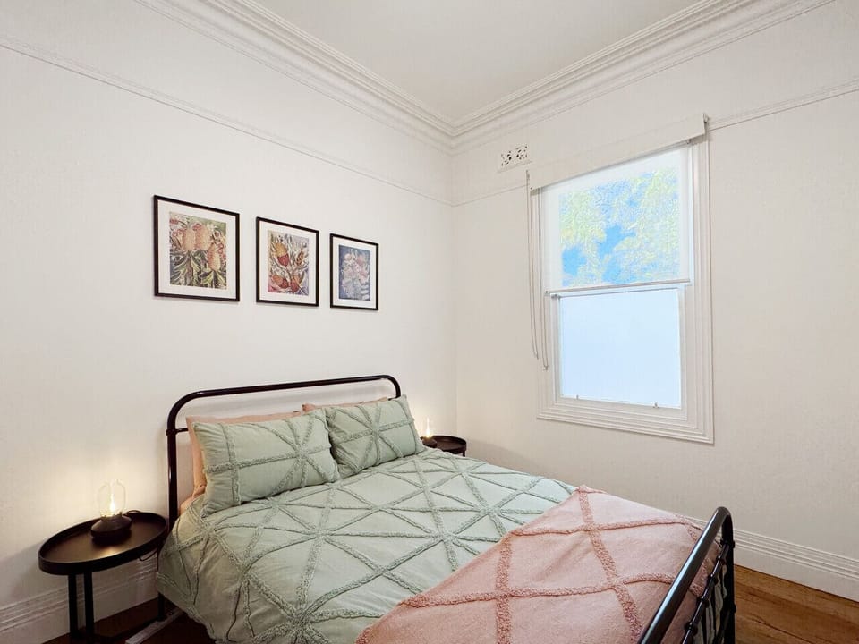 A spacious, light-filled room with thoughtful décor and a comfortable bed, complemented by a decorative fireplace and classic features. A peaceful retreat to recharge during your visit.