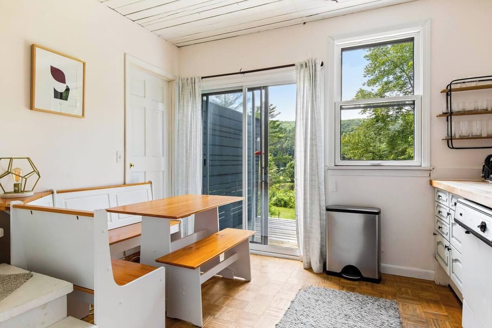 Cozy kitchen nook looks out over the deck, pond below, and hills beyond.