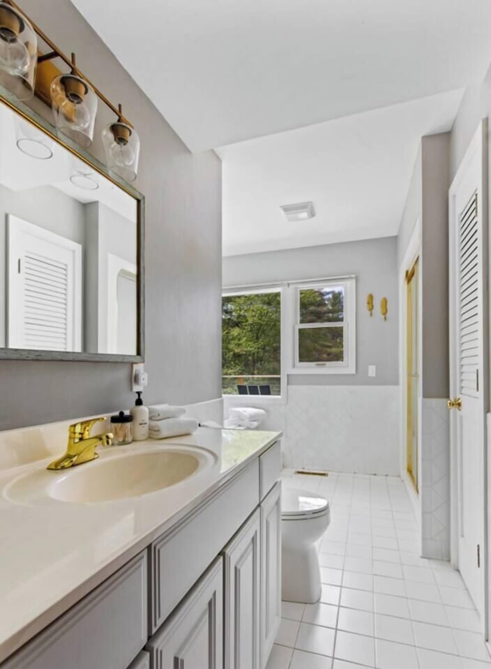 Master bath with lots of light and view overlooking the deck, hills beyond and pond below.