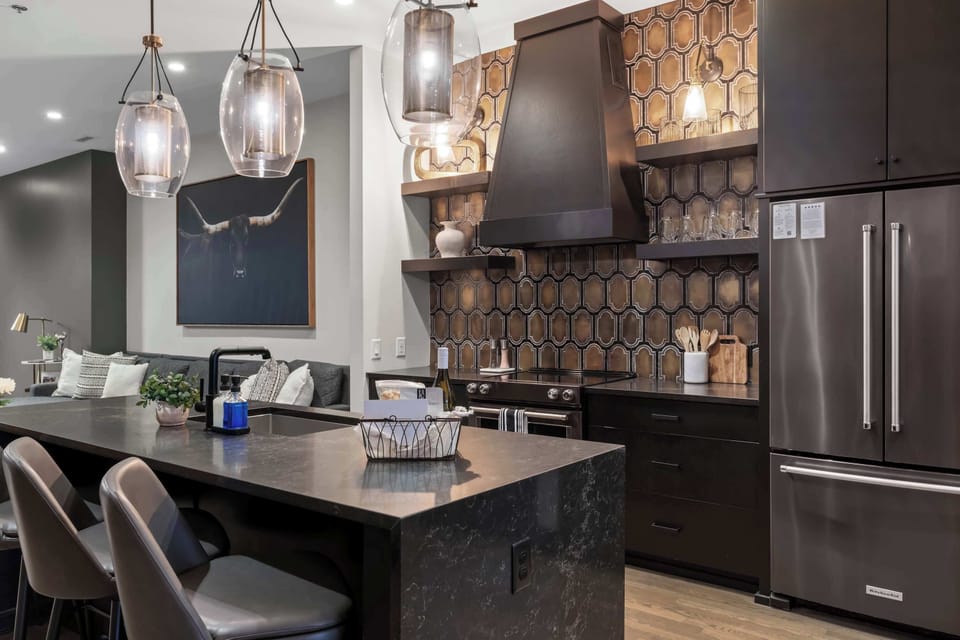 Spacious island with seating for three, stylish pendant lighting, and an open layout that flows seamlessly into the living and dining areas.
