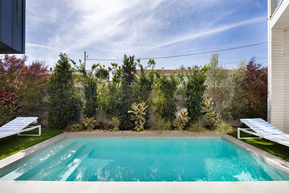 Private courtyard pool surrounded by lush landscaping