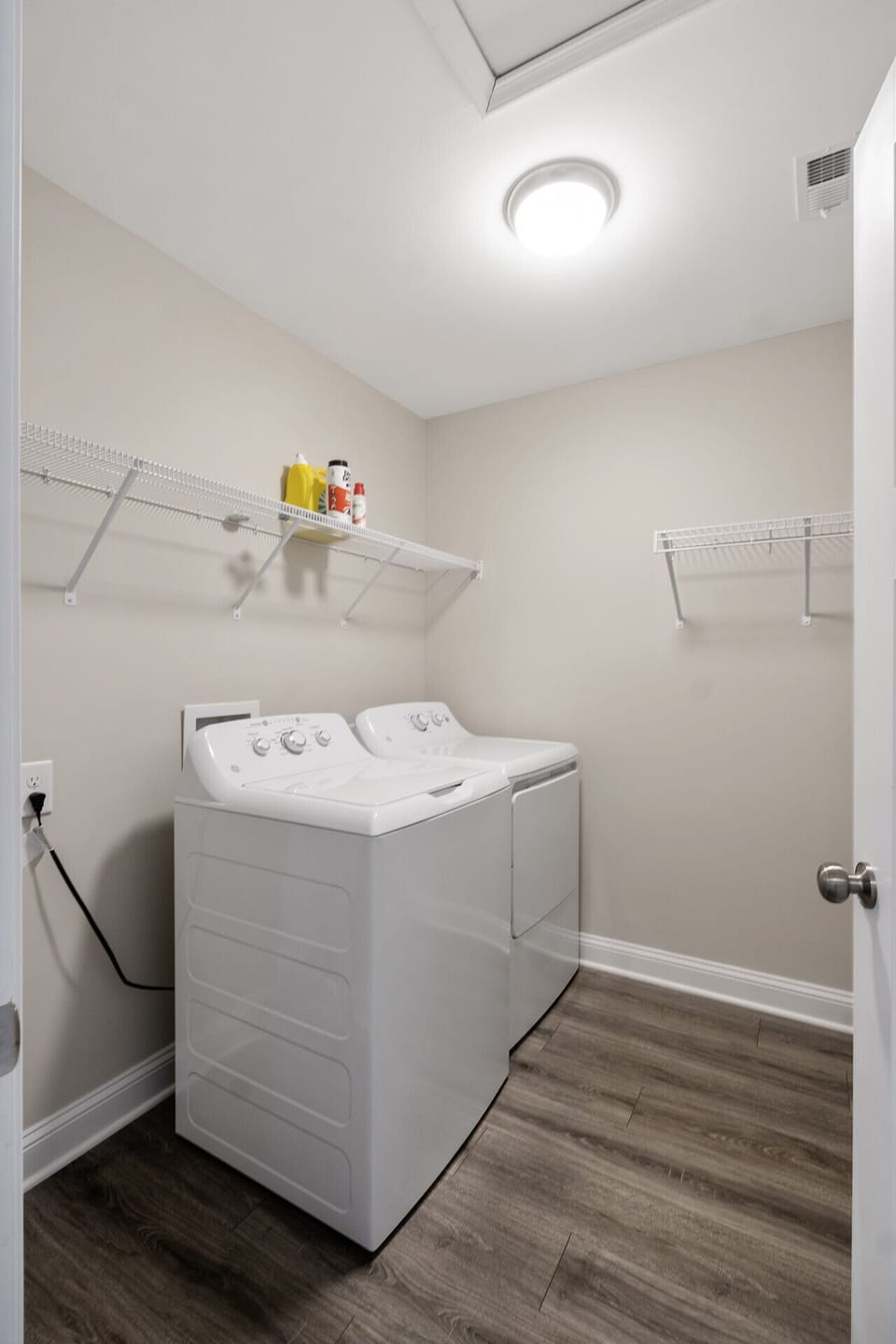Convenient in-home laundry with a washer, dryer, and extra shelving for storage