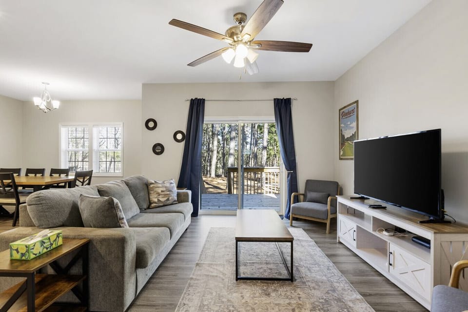 Bright and inviting living space with cozy seating, a large TV, and natural light—perfect for relaxation!