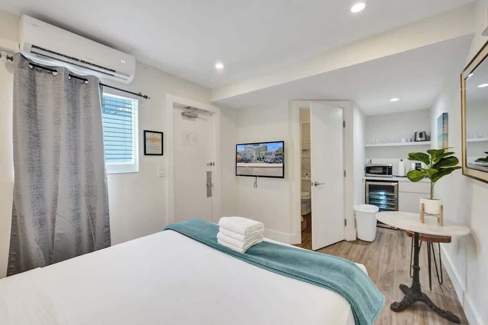 Bedroom with wall-mounted TV and kitchenette