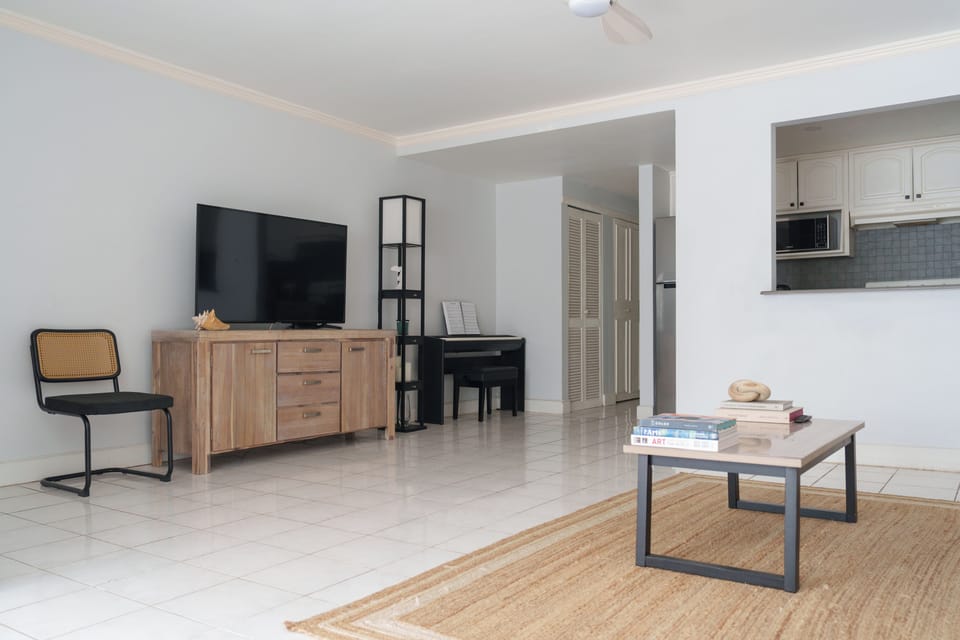 Living room with large smart TV and piano