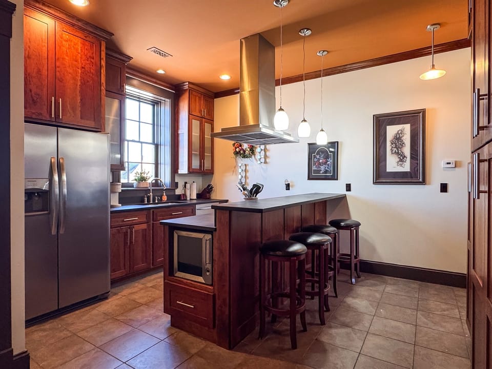 Custom designed kitchen with granite island and island seating to enjoy family cooking with all the extra kitchen amenities at Tamm Loft.