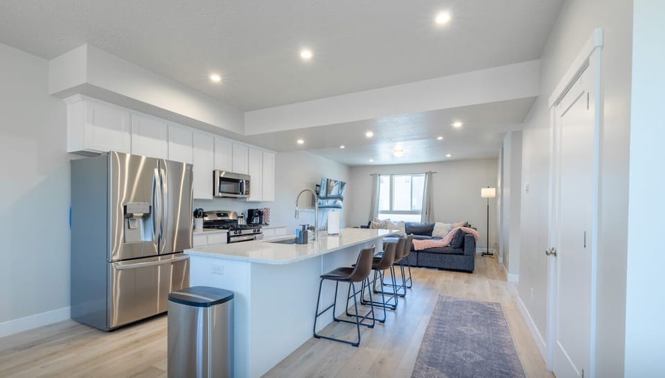 Fully equipped kitchen with sleek finishes and breakfast bar, ideal for cooking and gathering.