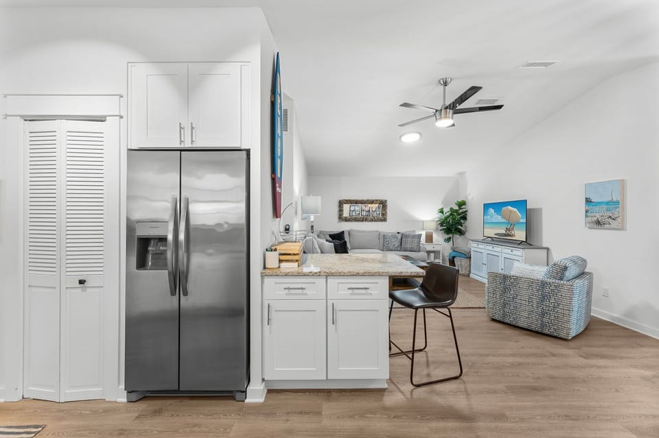 modern open-concept kitchen and living area with stainless steel appliances and comfortable seating