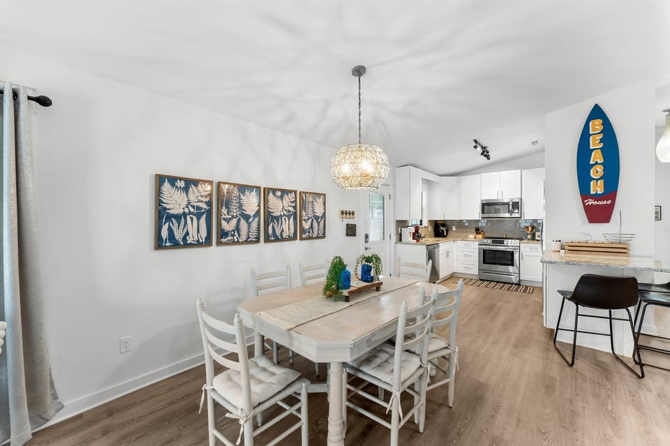 Dining area with coastal decor adjacent to a modern kitchen