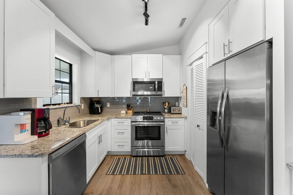 Modern kitchen with stainless steel appliances and granite countertops.