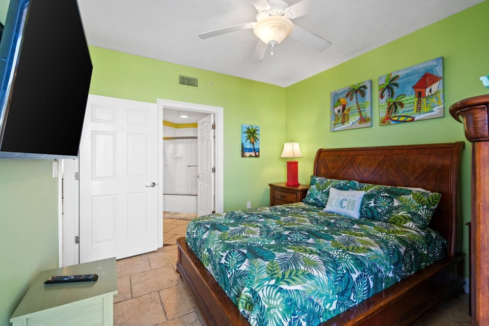 Tropical-themed bedroom with a comfortable bed and vibrant green walls.