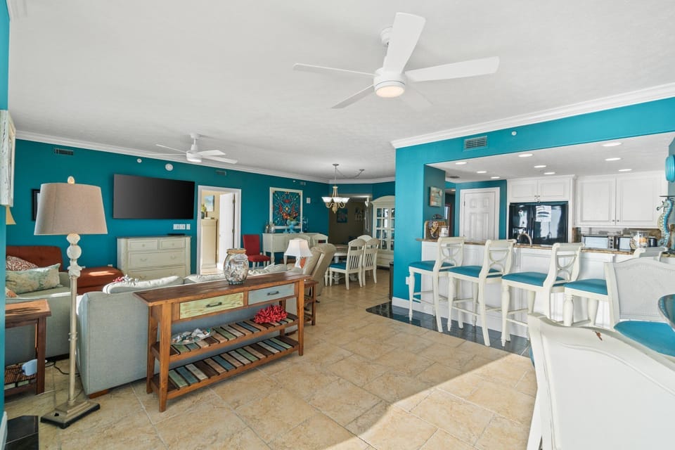 Open living area with vibrant turquoise walls and a breakfast bar seating four.