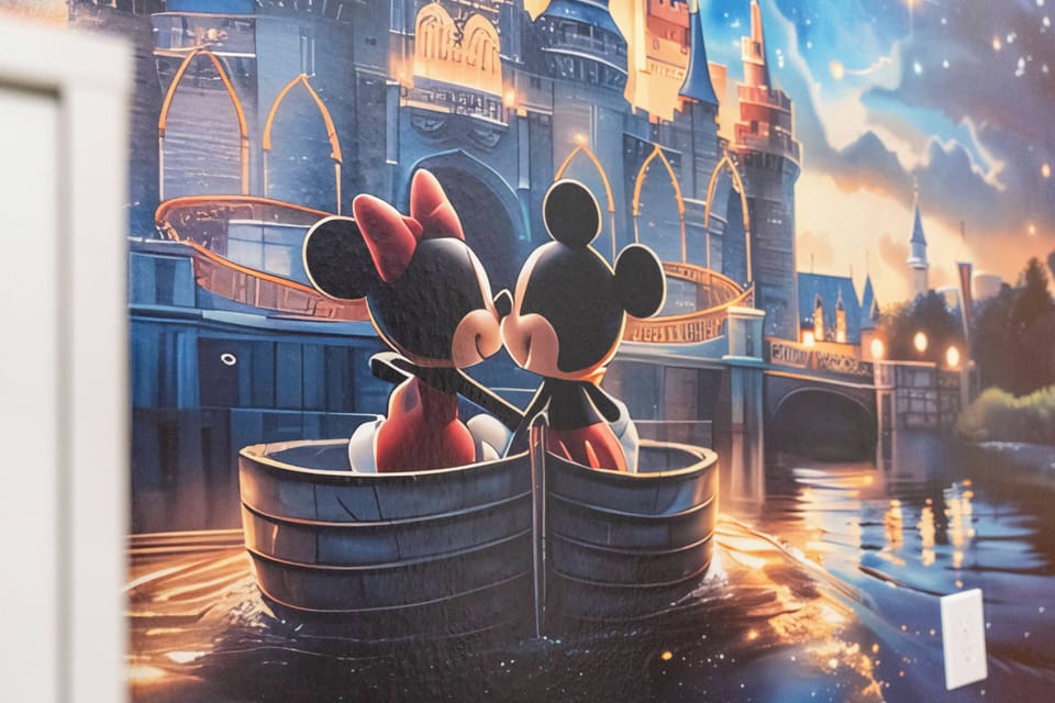Experience whimsy with this vibrant mural featuring beloved characters in a romantic moment on a serene waterway, framed by a fairy-tale castle that adds charm, making it ideal for families and couples seeking a touch of magic.