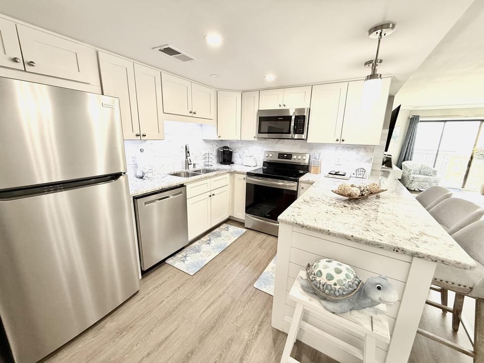 Bright, modern kitchen with stainless steel appliances and breakfast bar