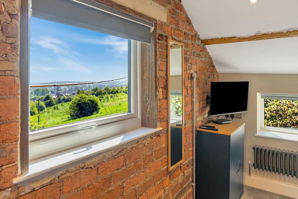 Wake to sweeping valley views through the exposed-brick window of this hillside bedroom.