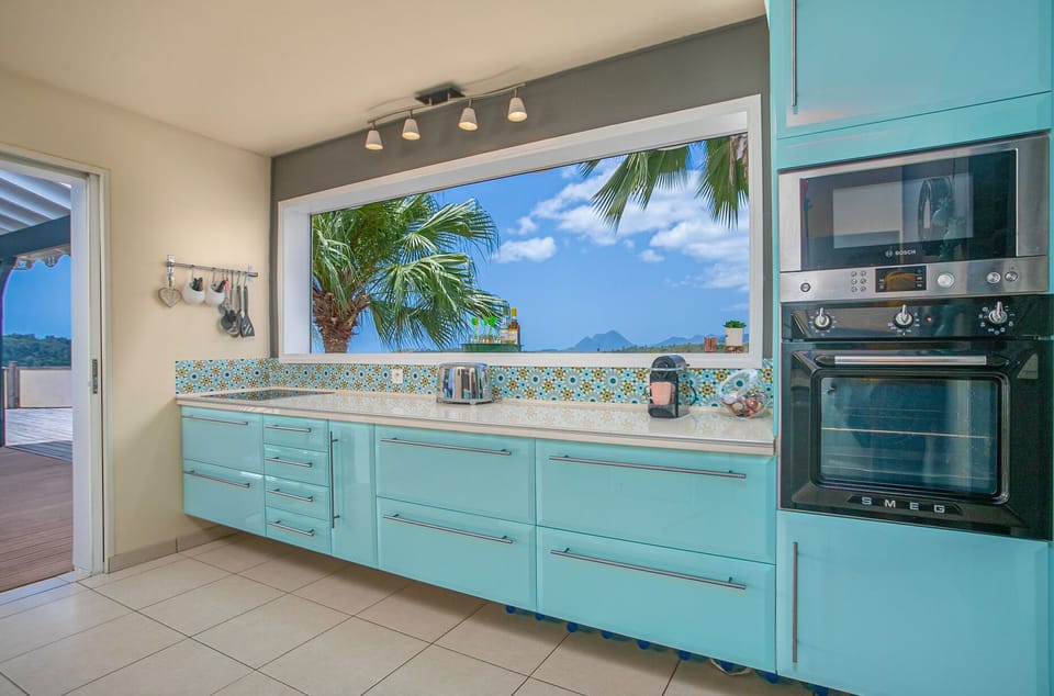 The fully-equipped kitchen opens onto the living room and outdoor dining area.