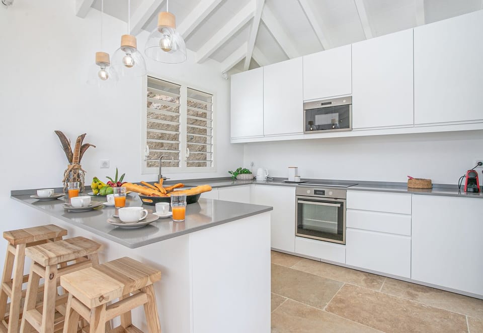 The kitchen of the Blue Light Villa is open to the living room with a view of the sea. Ideal for entertaining family or friends and sharing special moments in Martinique.