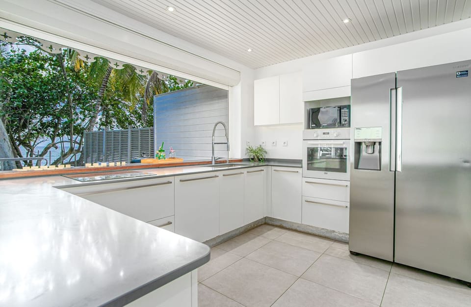 Modern and functional, the kitchen of the Beach House extends onto the terrace. Ideal for preparing your best Creole dishes for friends or family.