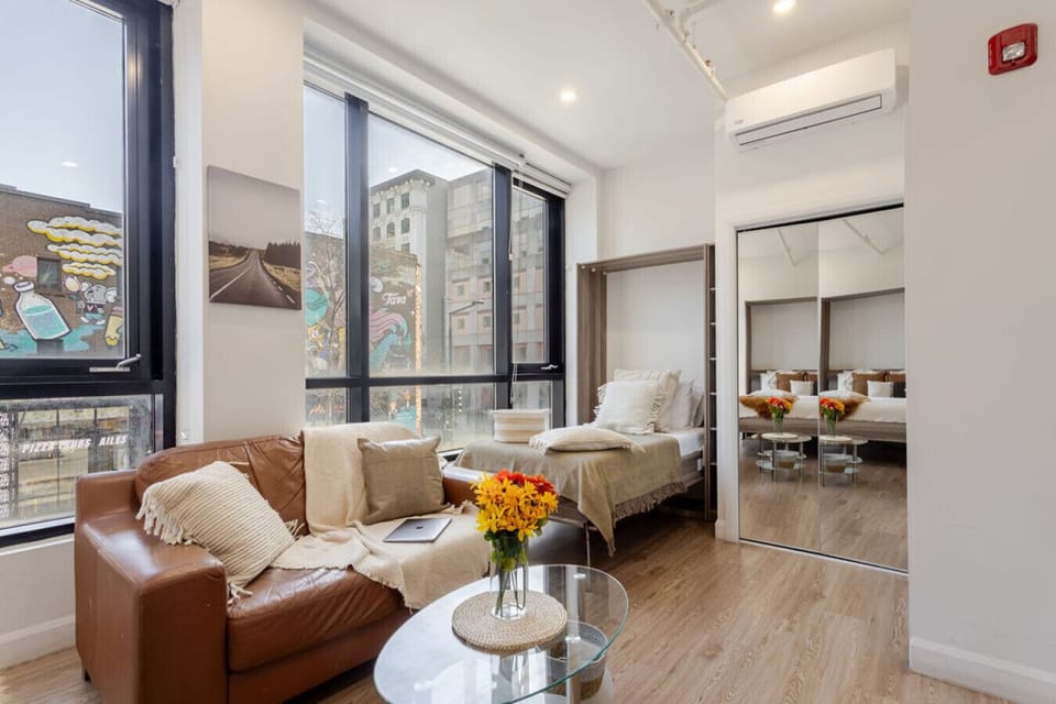 Tucked beside the windows, the single Murphy bed creates a compact sleep setup with natural light and comfort