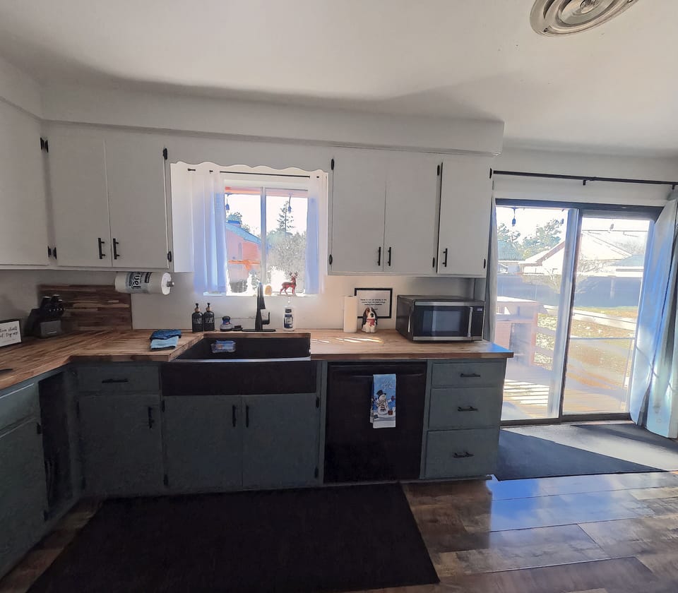 Charming kitchen with window views and deck entry.
