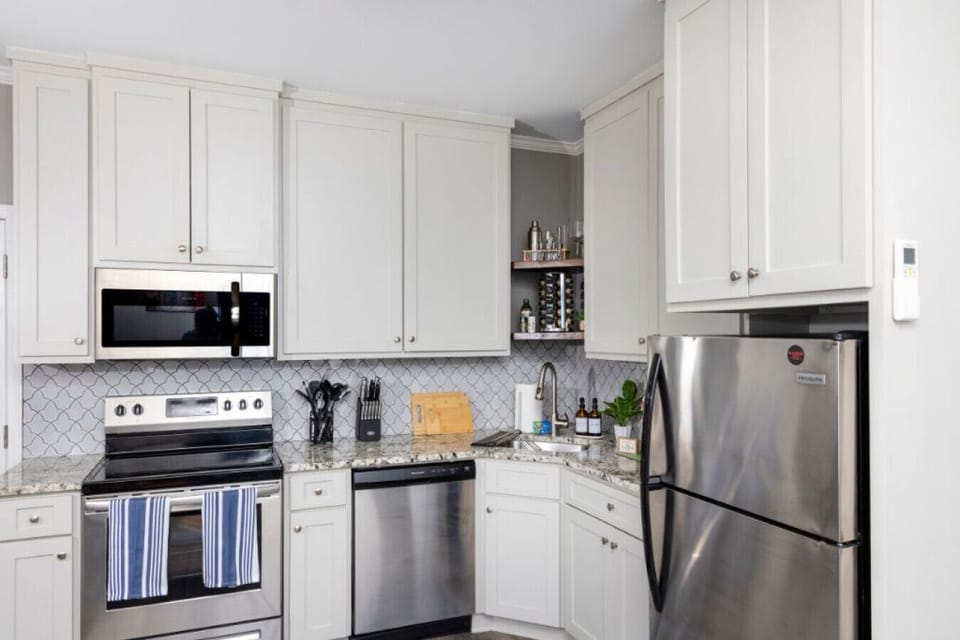 The stainless steel appliances and crisp white cabinets create the perfect backdrop for whipping up delicious meals. Who`s ready to cook?