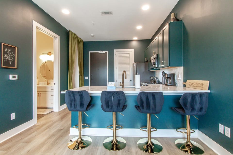 Entertain in style at the stunning bar with gold accents and bold blue walls!