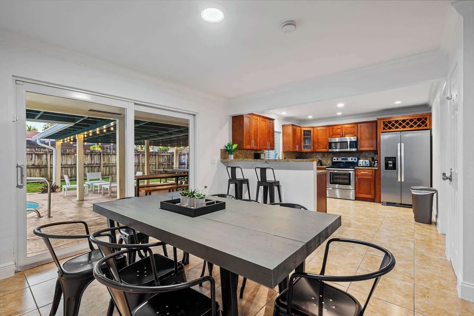 Dining table for eight, open to the kitchen and patio doors.