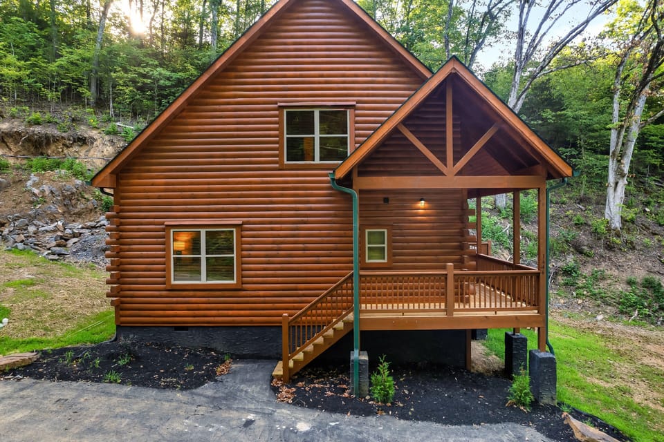 The cabin features a partial wrap-around deck with grill and hot tub.