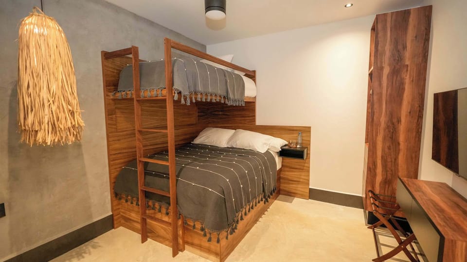 Habitación con litera; cama queen y cama individual y un pull-out individual. Cuenta con TV y AC