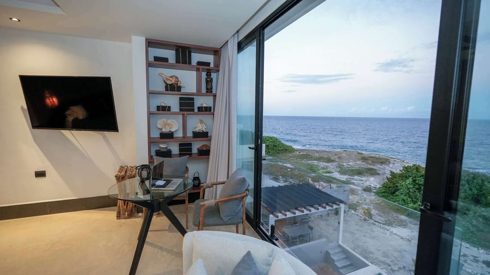 Vista al mar desde habitación, con TV y sillón individual 
