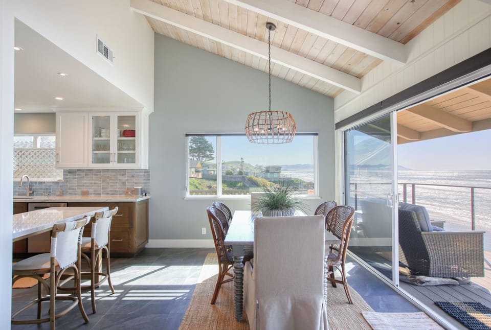 Savor panoramic Pacific views from the open-concept kitchen and dining area. Vaulted ceilings and expansive windows bring the coastline inside, creating the ultimate backdrop for every meal.