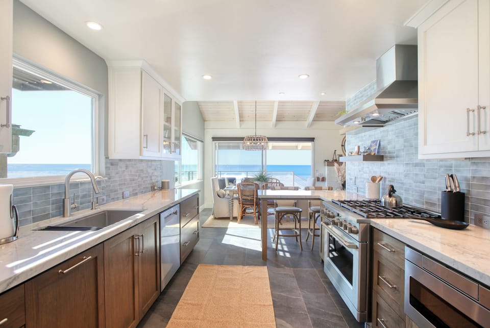 This beautifully remodeled kitchen is filled with an abundance of natural light and designed to be both spacious and welcoming, allowing multiple cooks to comfortably prepare meals together.