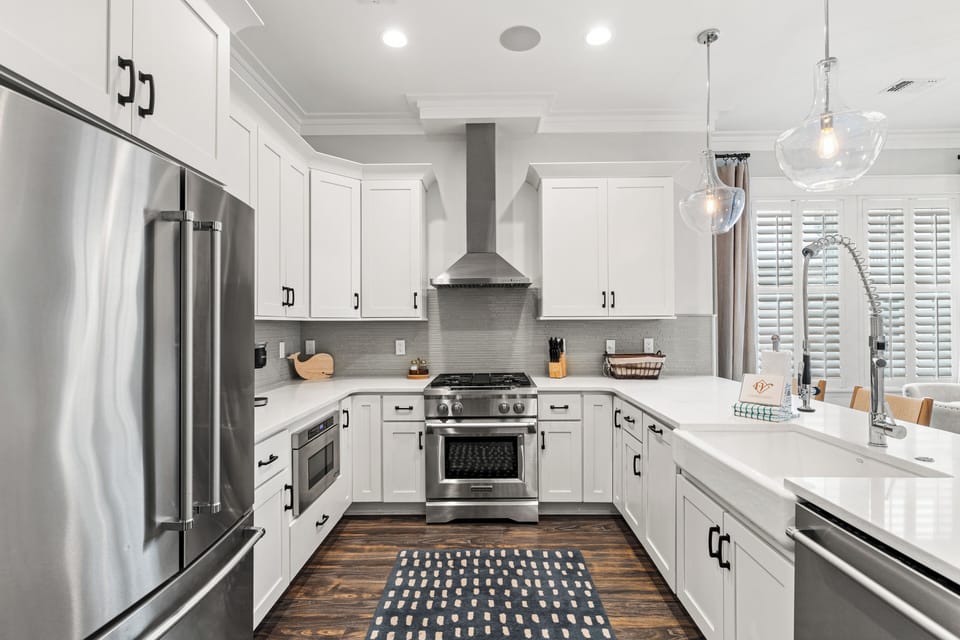 Your chef's dream awaits with pristine white cabinets, stainless steel appliances, and elegant pendant lighting creating the perfect space for culinary adventures.