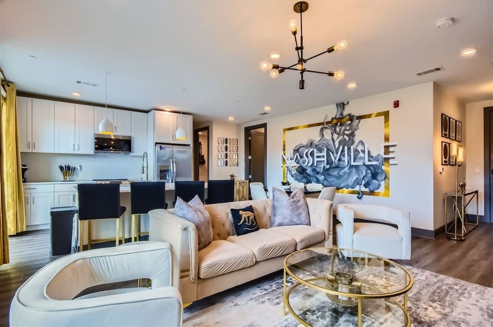 Living Room: Chic space with modern decor, golden accents, and vibrant Nashville art!